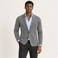 Blazer en maille à poches plaquées gris porté par un mannequin IVAREE, vue de face
