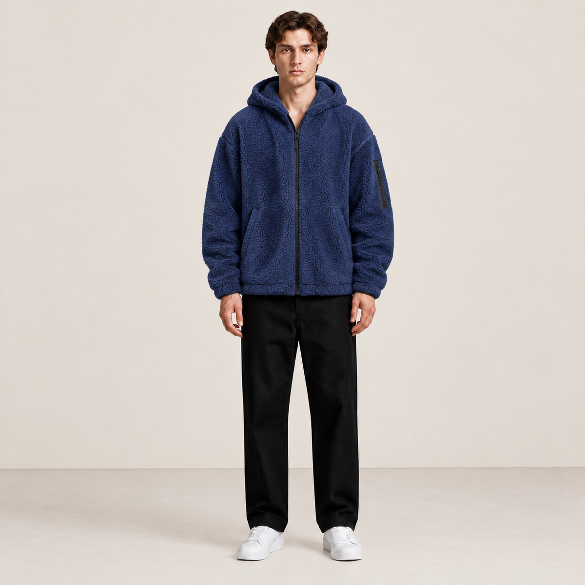 Bomber à capuche bleu marine effet fourrure, porté de face dans le studio IVAREE.