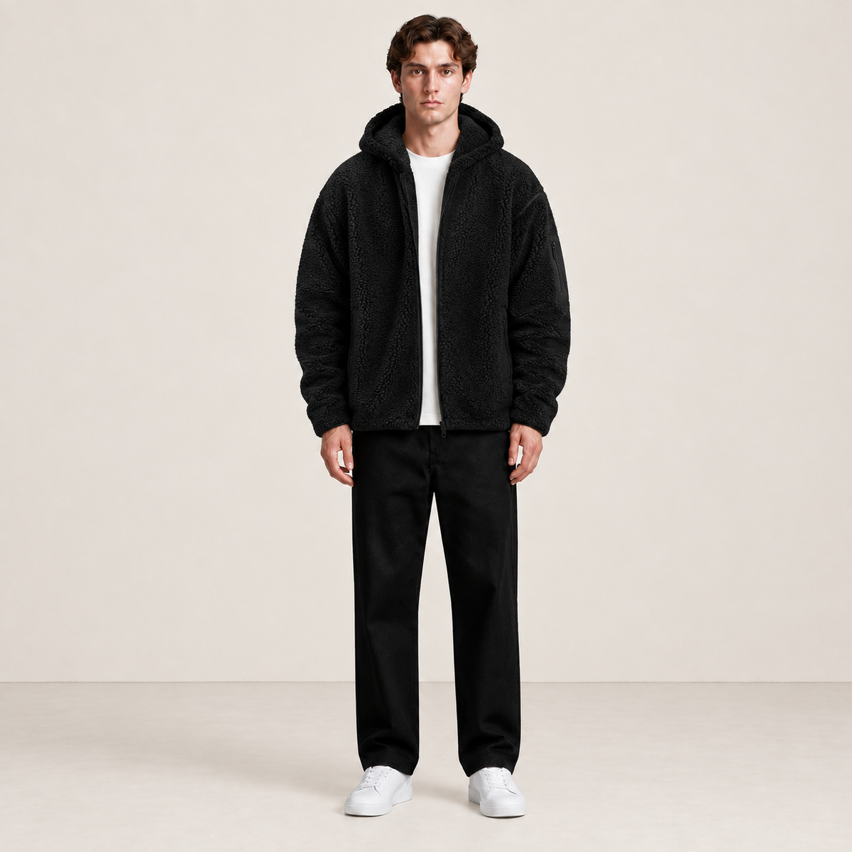 Bomber à capuche noir effet fourrure, porté de face dans le studio IVAREE.