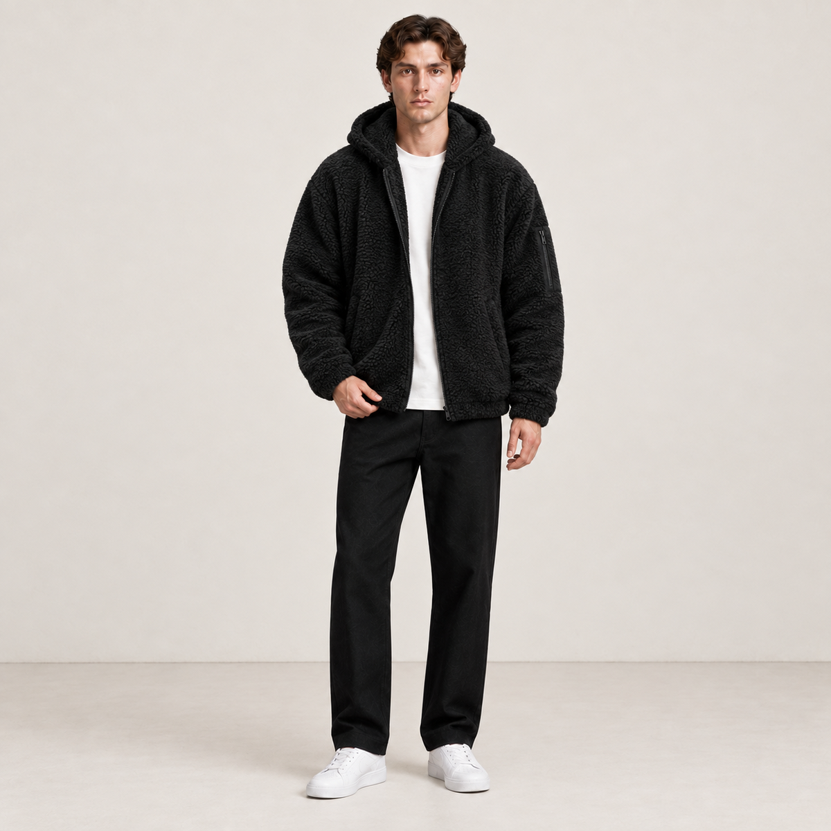 Bomber à capuche noir effet fourrure, porté de face dans une pose naturelle au studio IVAREE.
