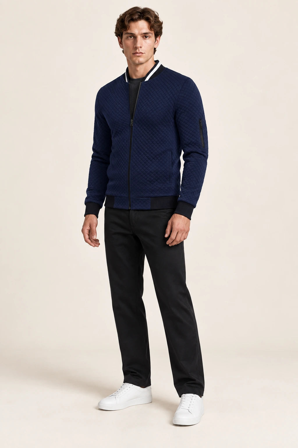 Veste bomber bleue matelassée en losanges avec col contrastant et poche zippée de manche, vue de face dans le studio IVAREE.