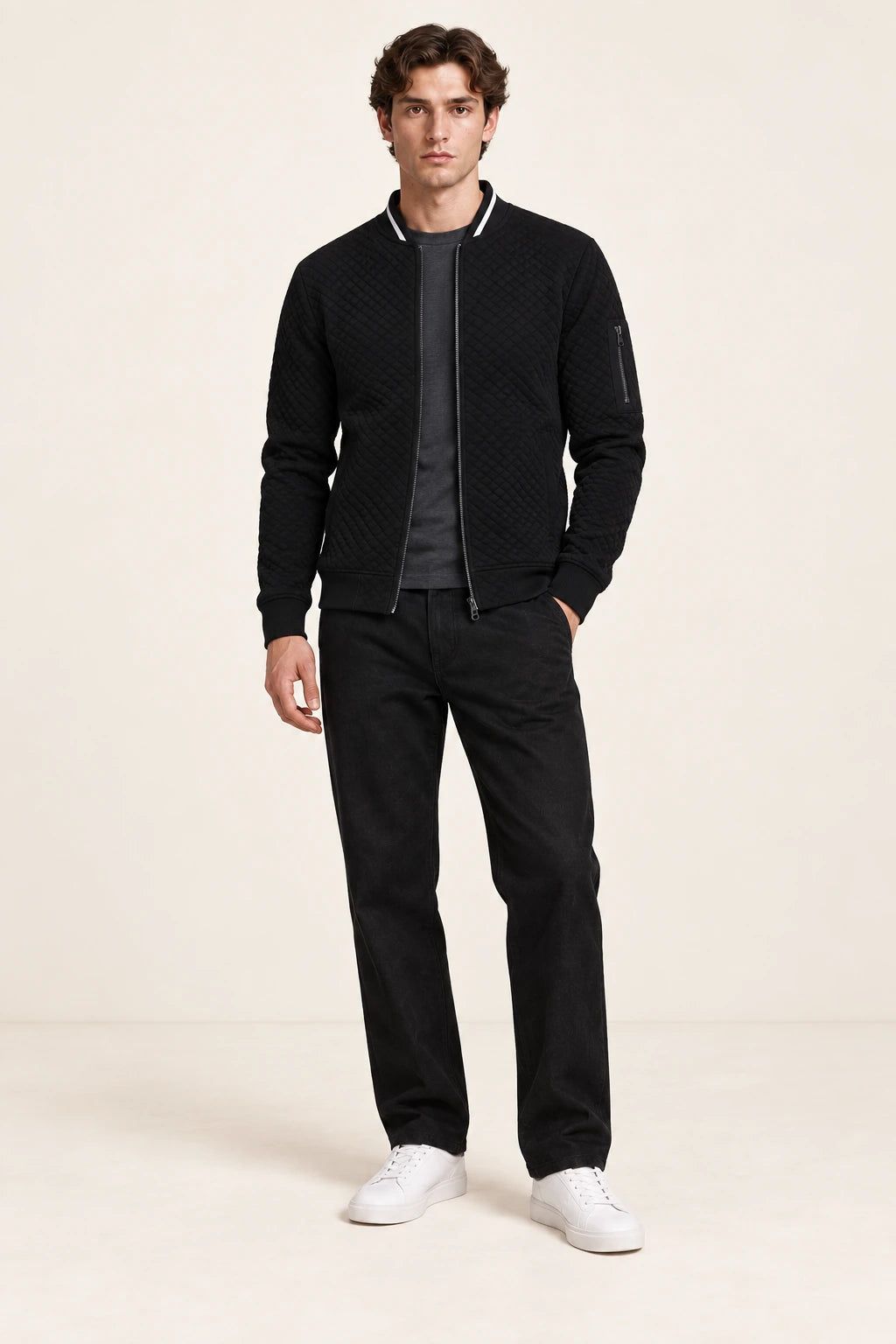 Veste bomber noire matelassée en losanges avec col contrastant et poche zippée de manche, vue de face dans le studio IVAREE.