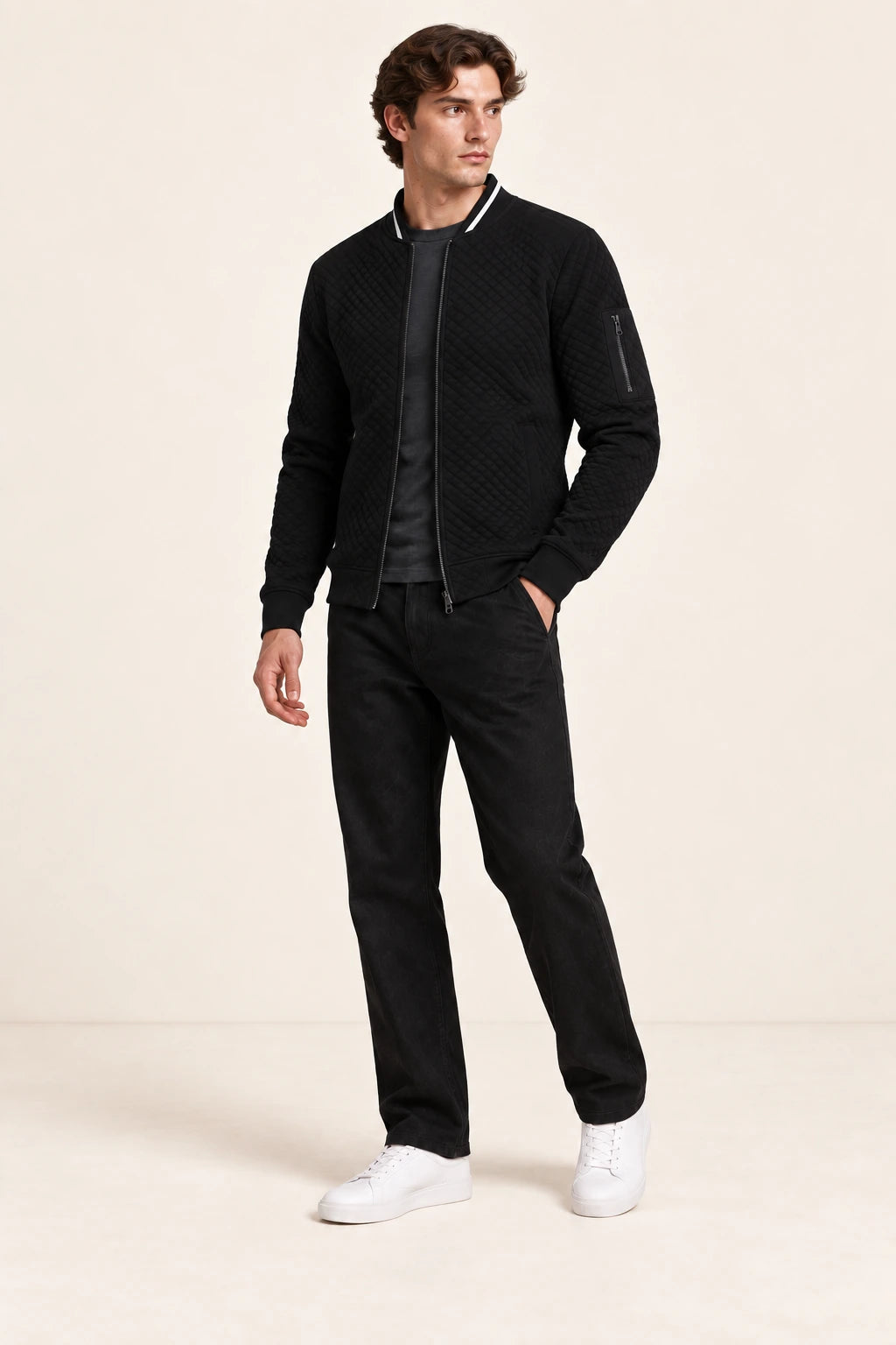 Veste bomber noire matelassée en losanges, portée de trois-quarts dans le studio IVAREE.