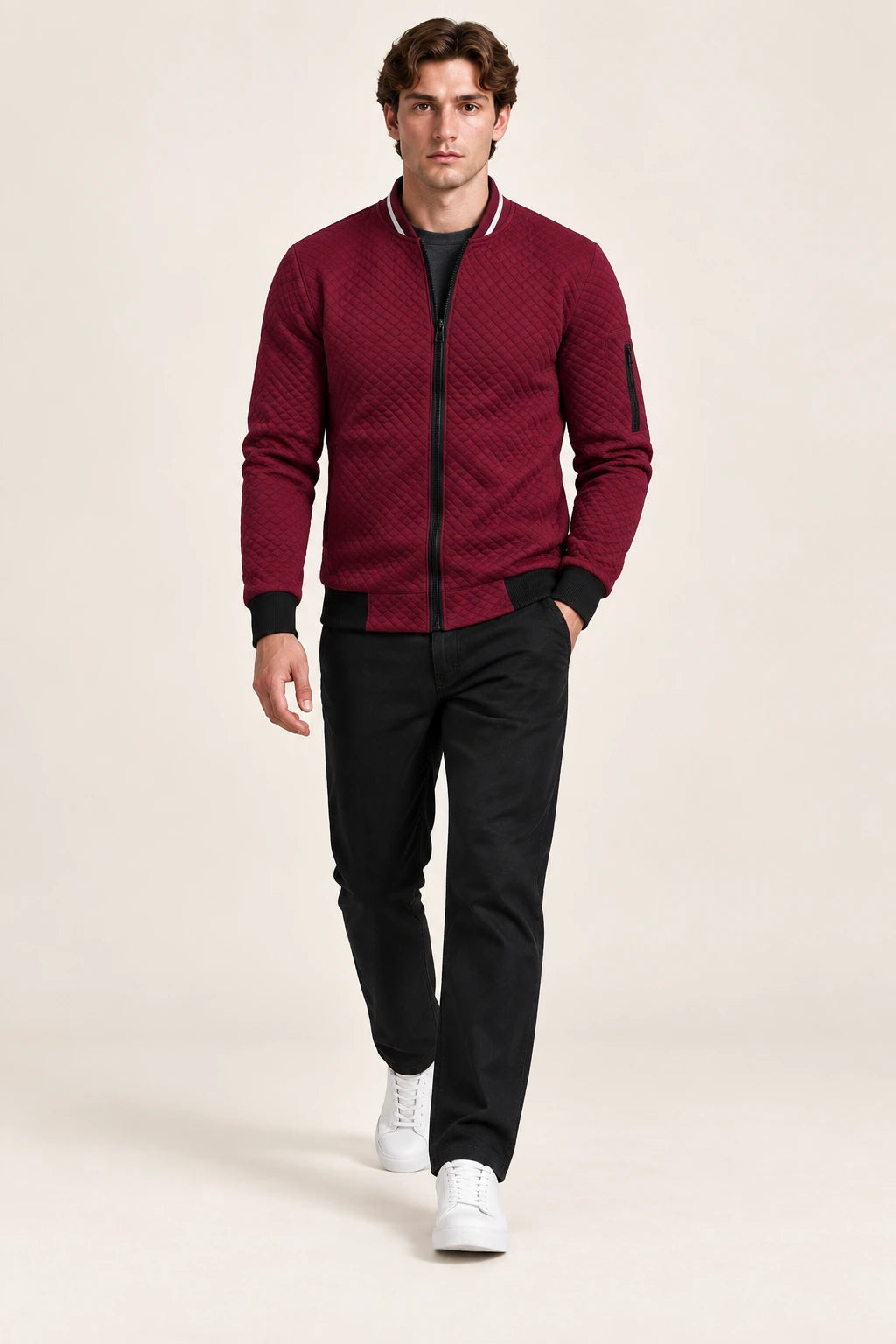 Veste bomber rouge matelassée en losanges avec col contrastant et poche zippée de manche, vue de face dans le studio IVAREE.