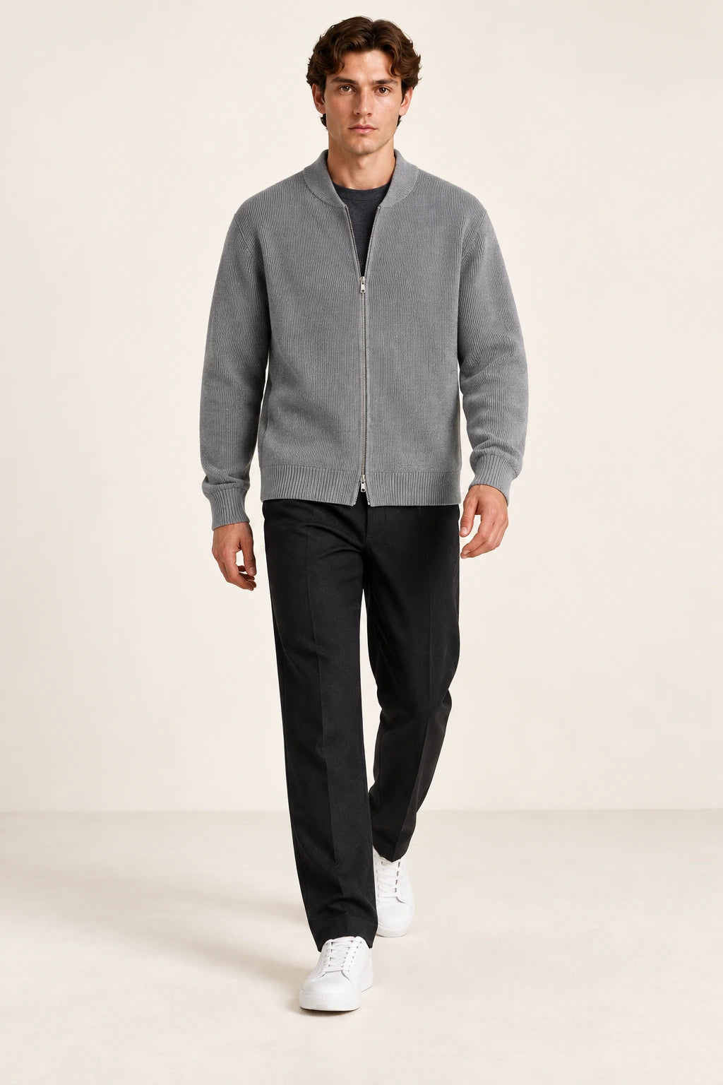 Cardigan gris en maille côtelée fine avec col court et fermeture zippée à double curseur, porté de face dans le studio IVAREE.