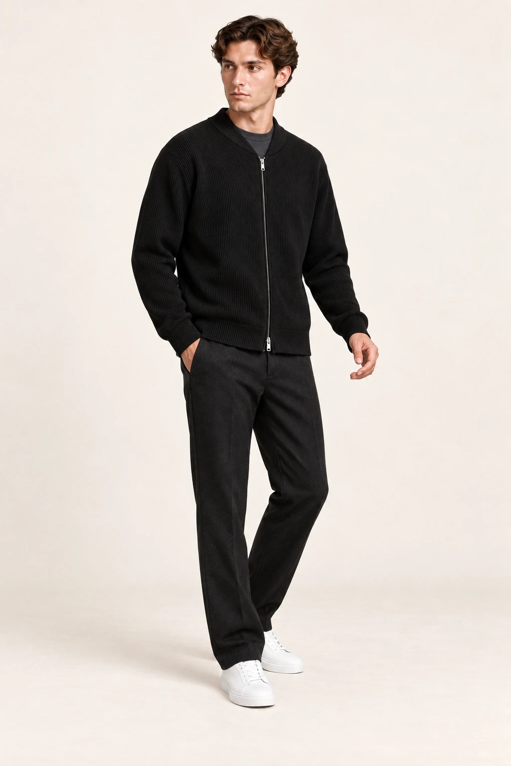 Cardigan noir en maille côtelée fine, troisième vue en pose décalée dans le studio IVAREE.