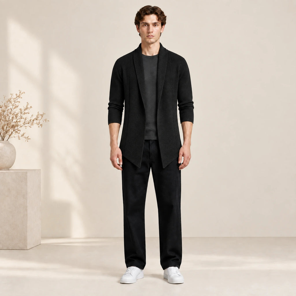 Cardigan long noir ouvert en maille côtelée, porté de face dans le studio IVAREE.