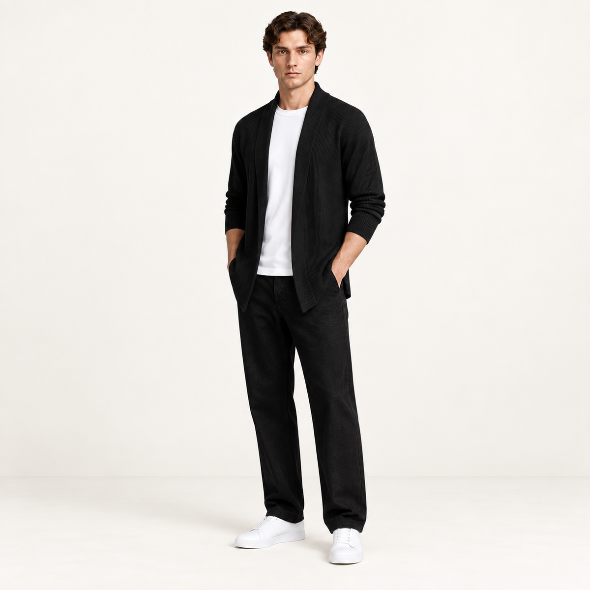 Cardigan long noir ouvert en maille côtelée, porté de trois-quarts dans le studio IVAREE.