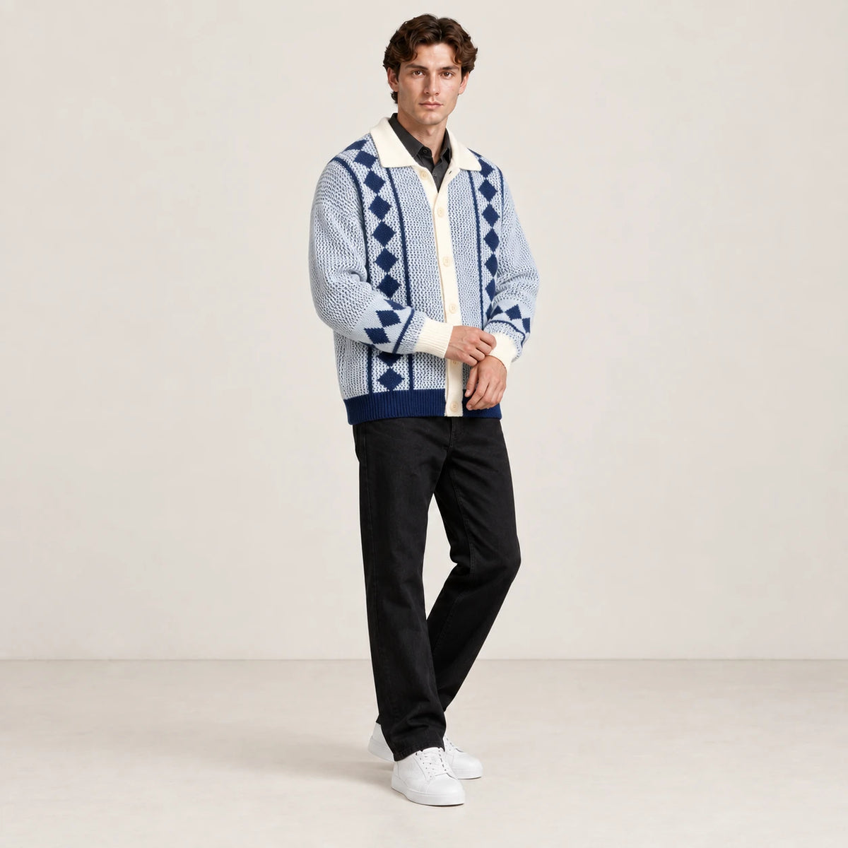 Cardigan bleu clair et écru en maille ajourée à losanges, porté en ajustant le poignet dans le studio IVAREE.