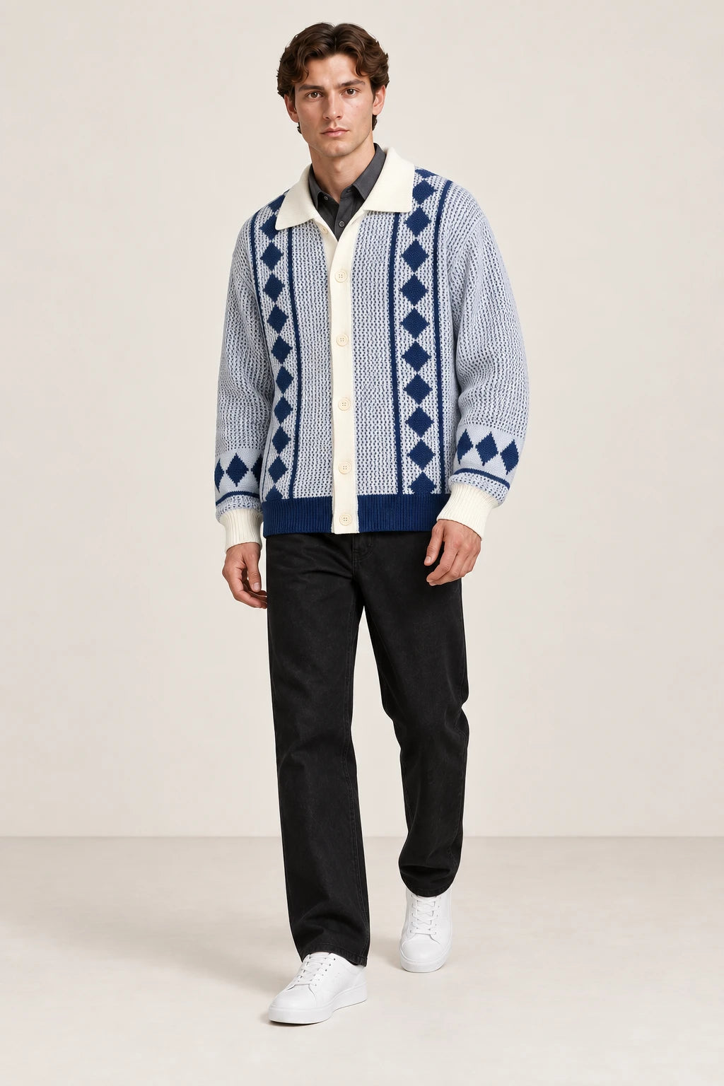 Cardigan bleu clair et écru en maille ajourée à losanges, porté en marche de trois-quarts dans le studio IVAREE.