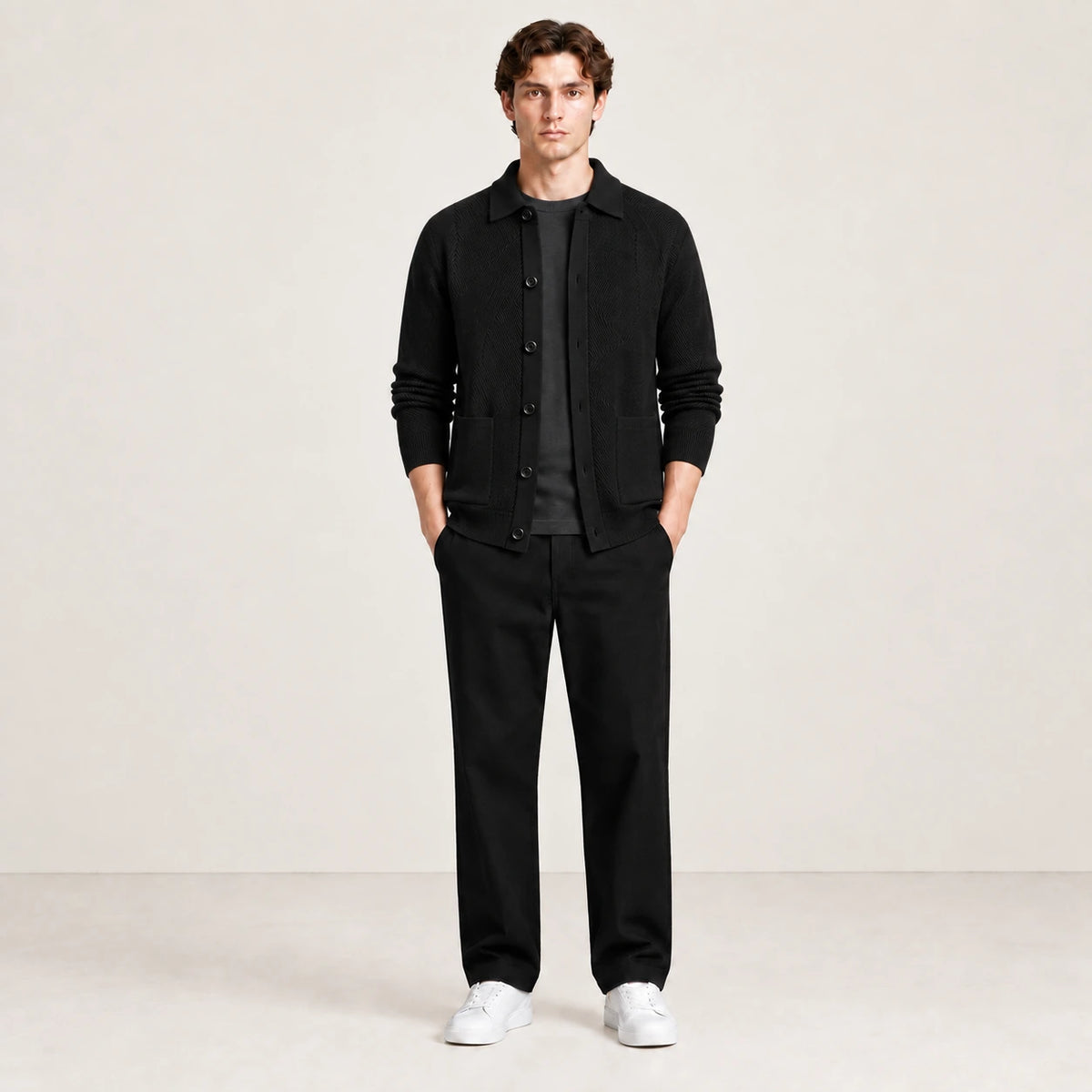 Cardigan noir en maille douce à manches longues, porté de face dans le studio IVAREE.
