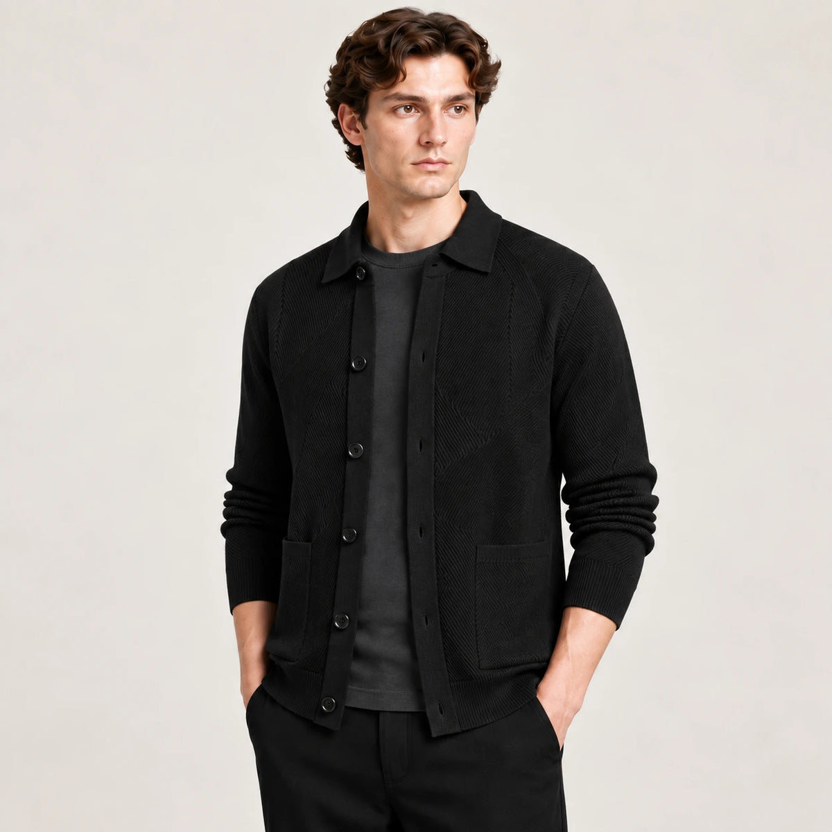 Cardigan noir en maille douce à manches longues, vu de trois-quarts avant dans le studio IVAREE.