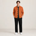 Cardigan orange en maille douce à manches longues, porté de face dans le studio IVAREE.