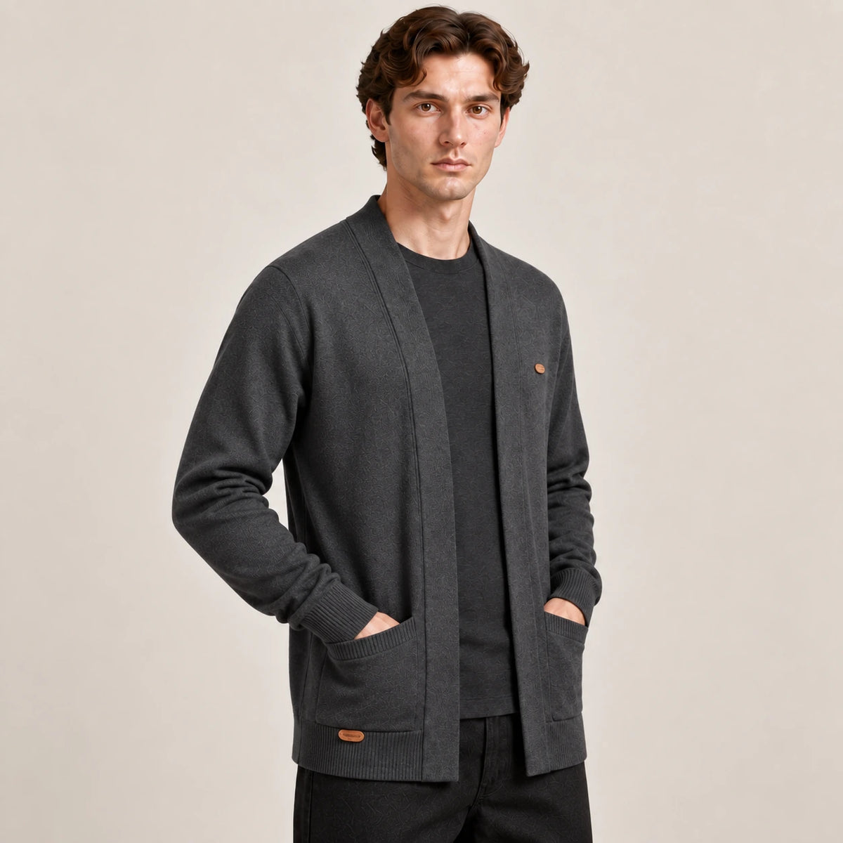 Cardigan ouvert gris foncé à col V en maille douce, vu de trois-quarts avant dans le studio IVAREE.