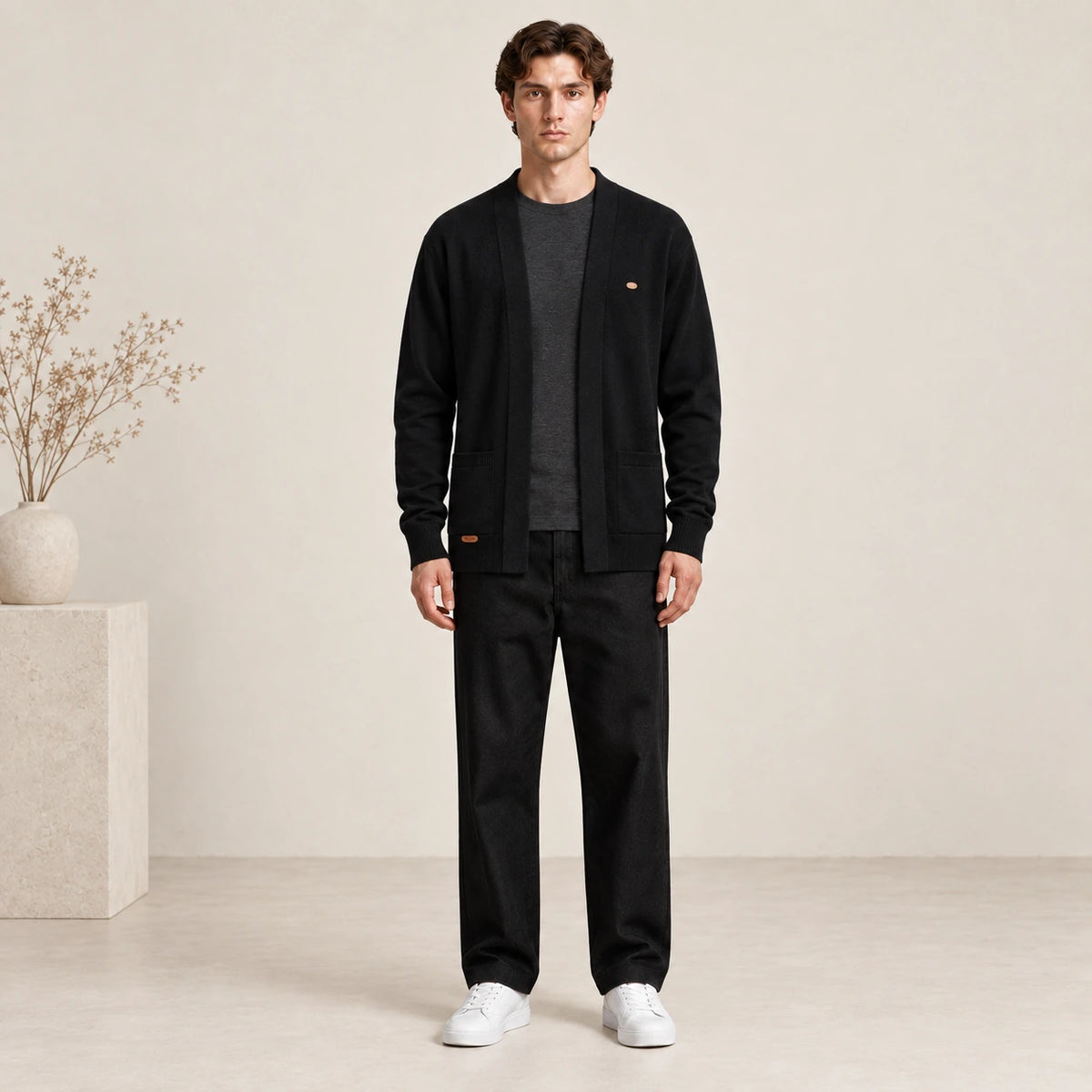 Cardigan ouvert noir à col V en maille douce, porté de face dans le studio IVAREE.