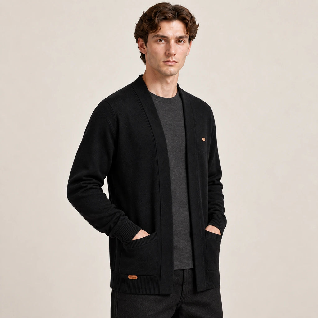 Cardigan ouvert noir à col V en maille douce, vu de trois-quarts avant dans le studio IVAREE.