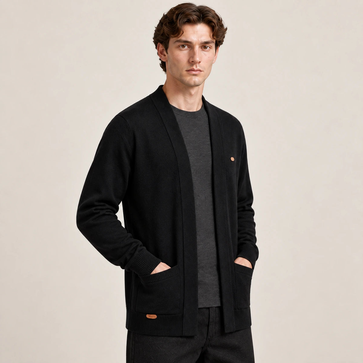 Cardigan ouvert noir à col V en maille douce, vu de trois-quarts avant dans le studio IVAREE.