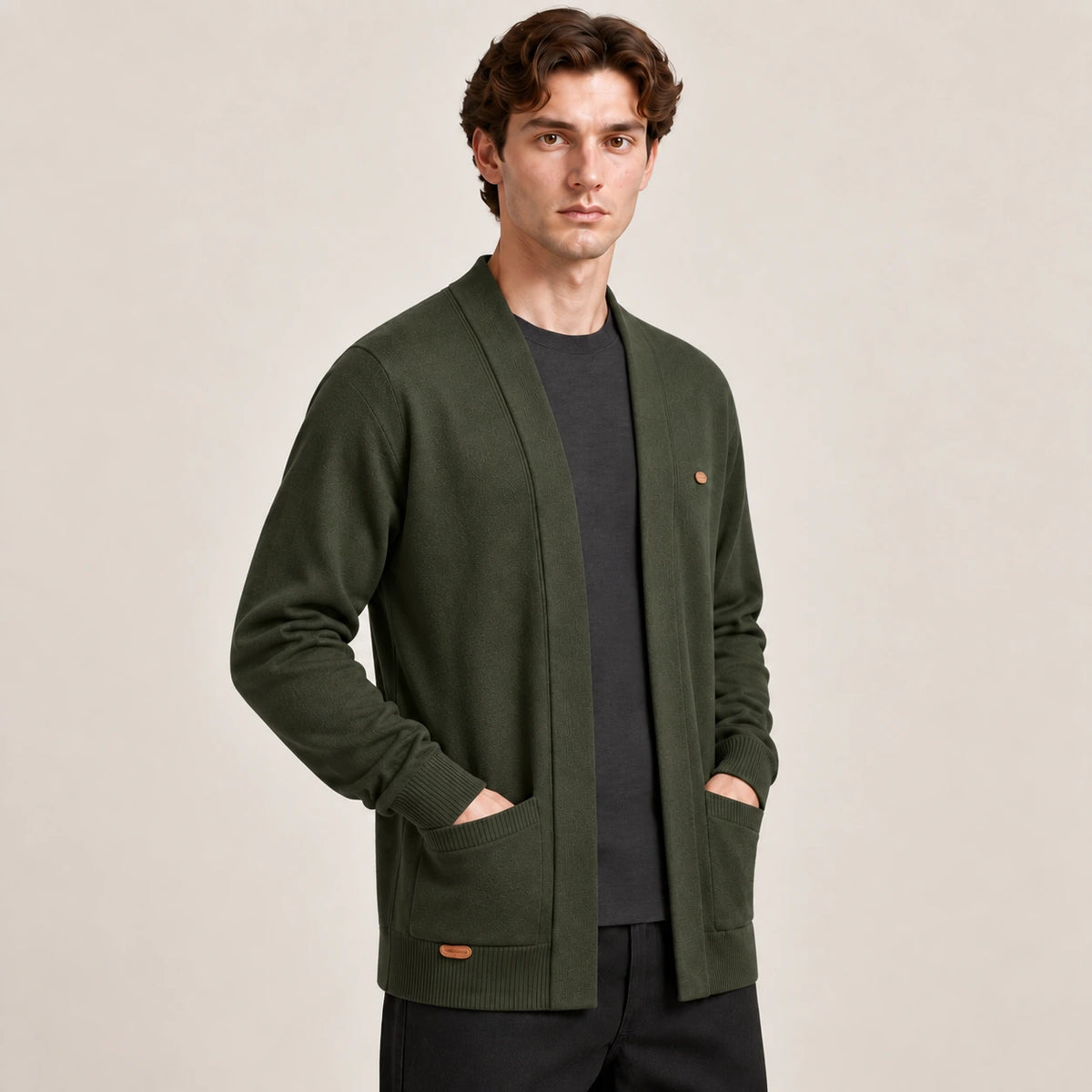 Cardigan ouvert vert foncé à col V en maille douce, vu de trois-quarts avant dans le studio IVAREE.
