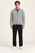 Cardigan gris clair en maille fine coupe slim avec col court et fermeture zippée à double curseur, porté de face dans le studio IVAREE.