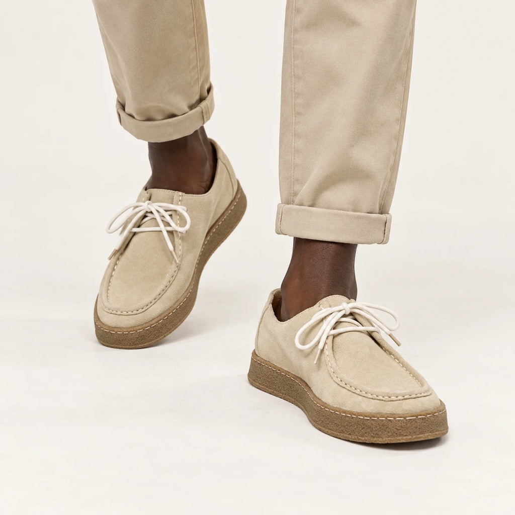 Chaussures moc-toe en daim à semelle crêpe beige, portées en marche dans le studio IVAREE