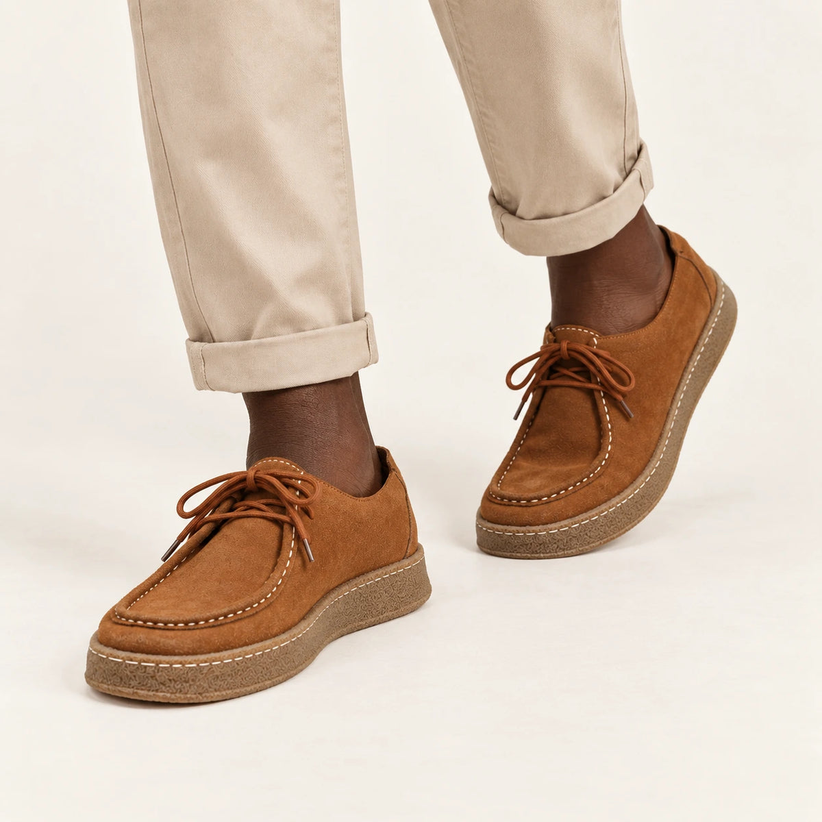 Chaussures moc-toe en daim à semelle crêpe caramel, portées en marche dans le studio IVAREE