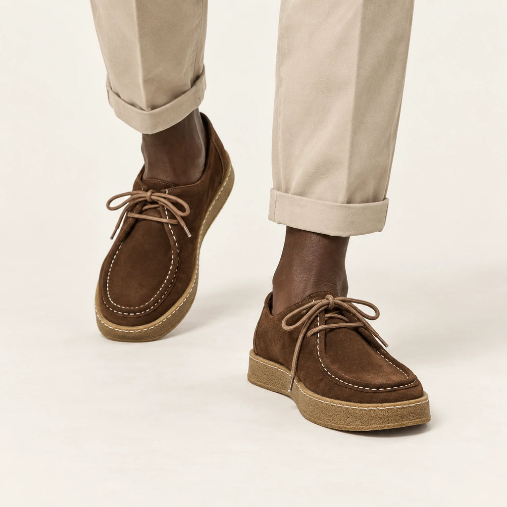 Chaussures moc-toe en daim à semelle crêpe marron, portées en marche dans le studio IVAREE