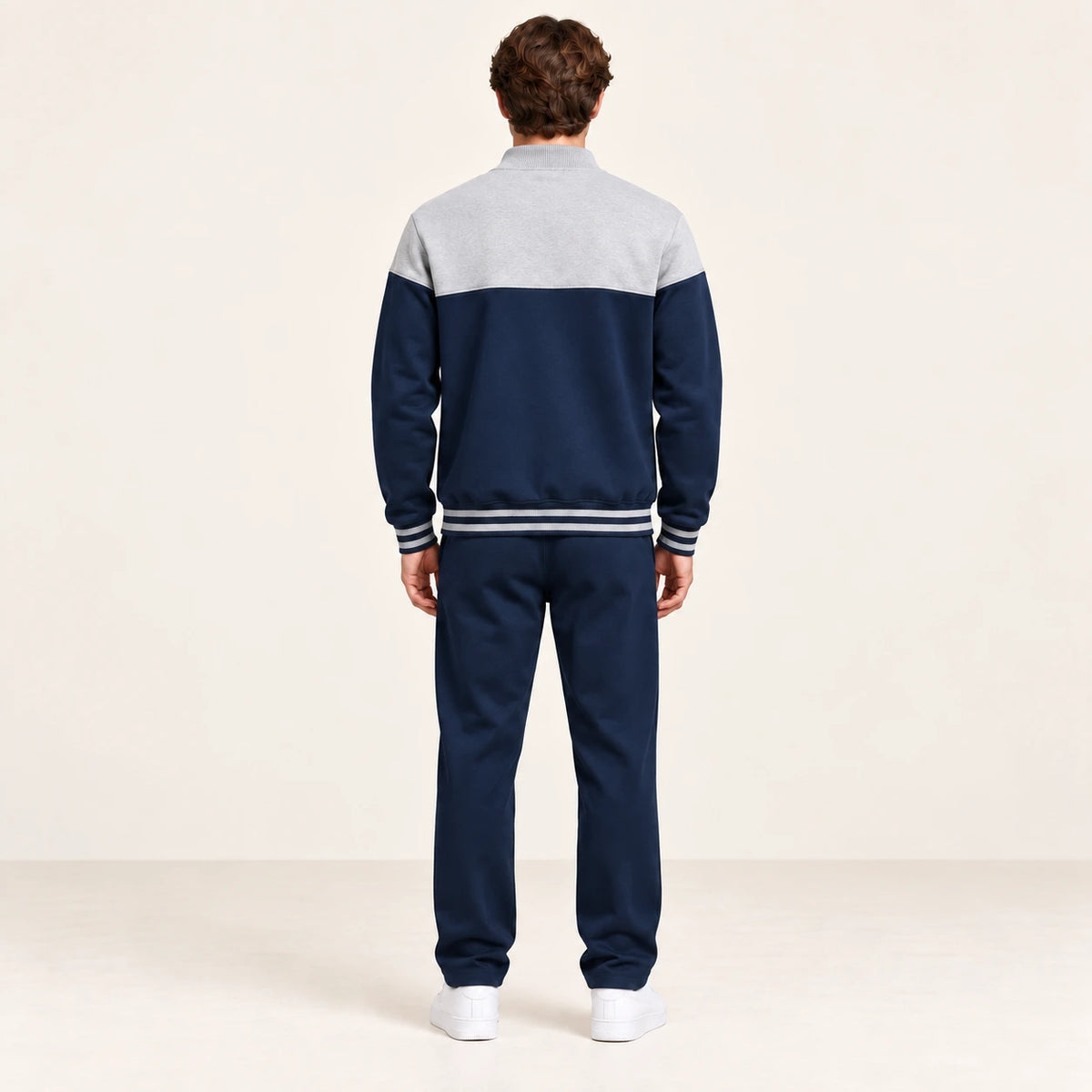 Ensemble de survêtement esprit baseball gris clair et bleu marine, porté de dos en studio ivoire