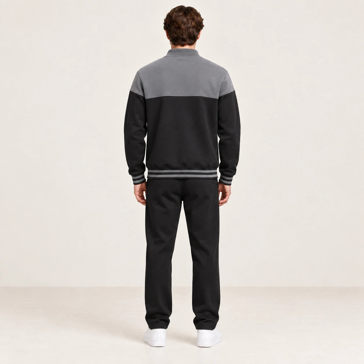 Ensemble de survêtement esprit baseball gris et noir, porté de dos en studio ivoire