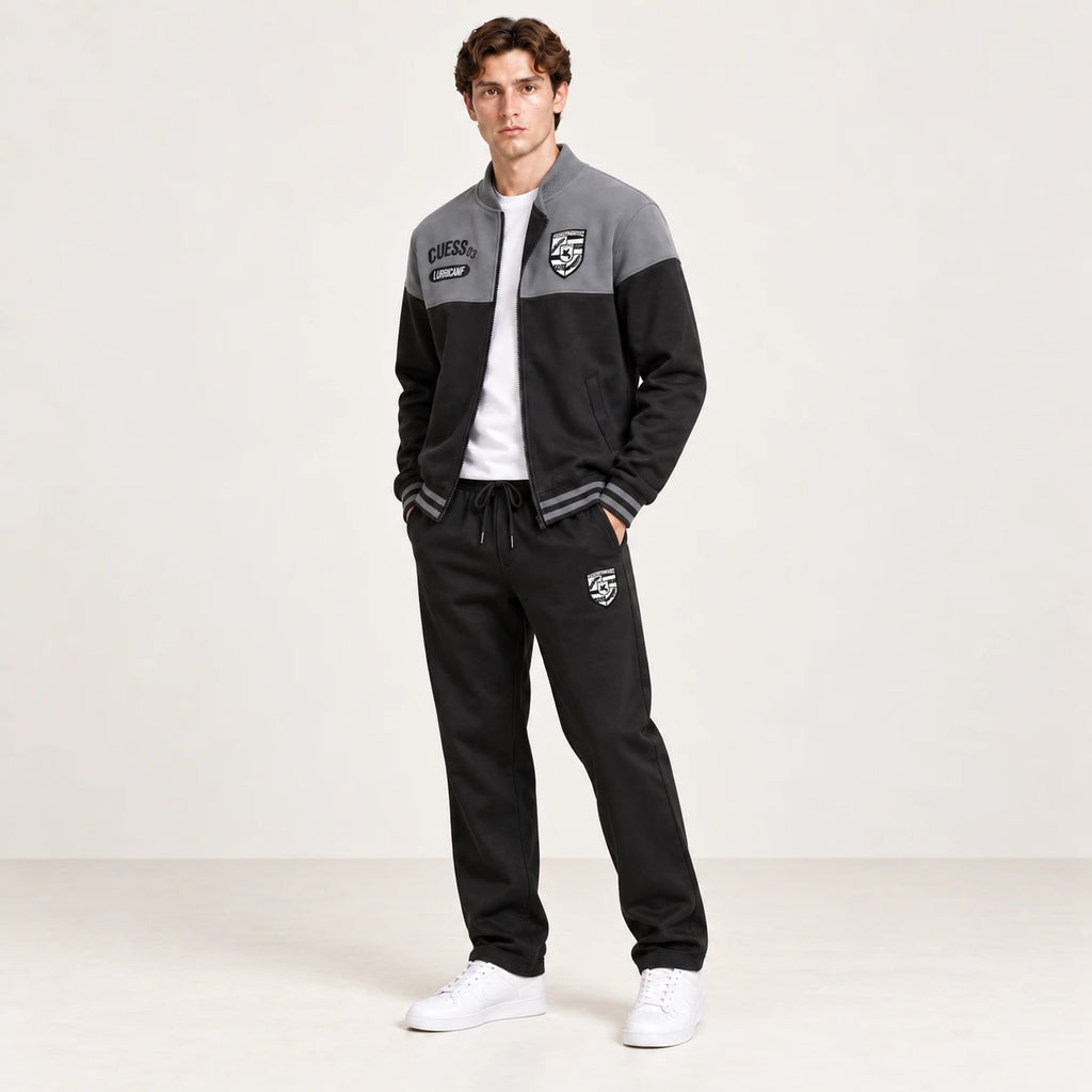 Ensemble de survêtement esprit baseball gris et noir, porté en vue trois-quarts en studio ivoire