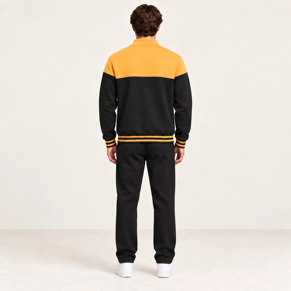 Ensemble de survêtement esprit baseball jaune et noir, porté de dos en studio ivoire