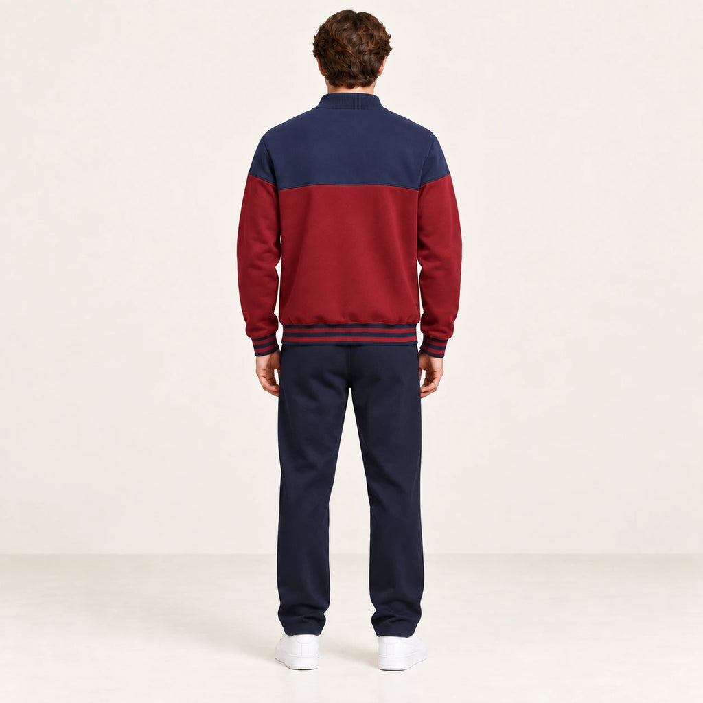 Ensemble de survêtement esprit baseball rouge et bleu marine, porté de dos en studio ivoire