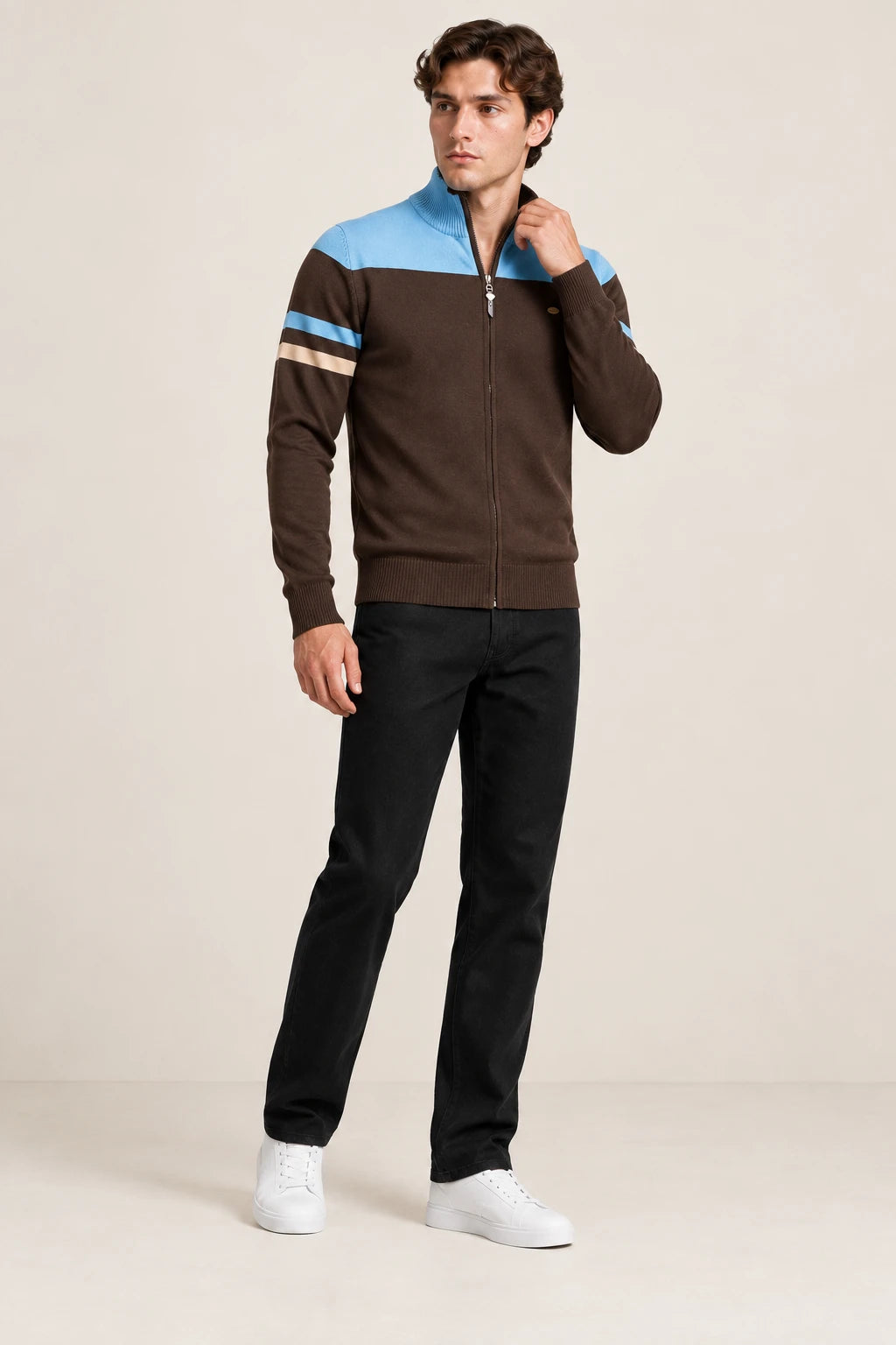 Gilet zippé brun et bleu ciel à col cheminée, porté en ajustant le col dans le studio IVAREE.