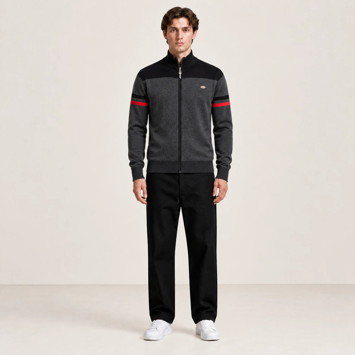 Gilet zippé gris anthracite et noir à col cheminée et rayures rouges sur les manches, vue de face dans le studio IVAREE.