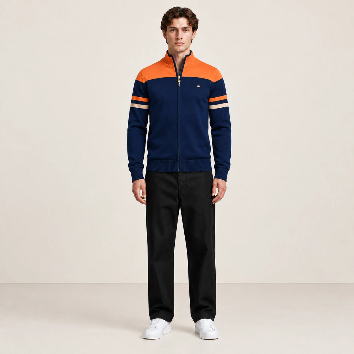 Gilet zippé bleu marine et orange à col cheminée et rayures contrastées sur les manches, vue de face dans le studio IVAREE.