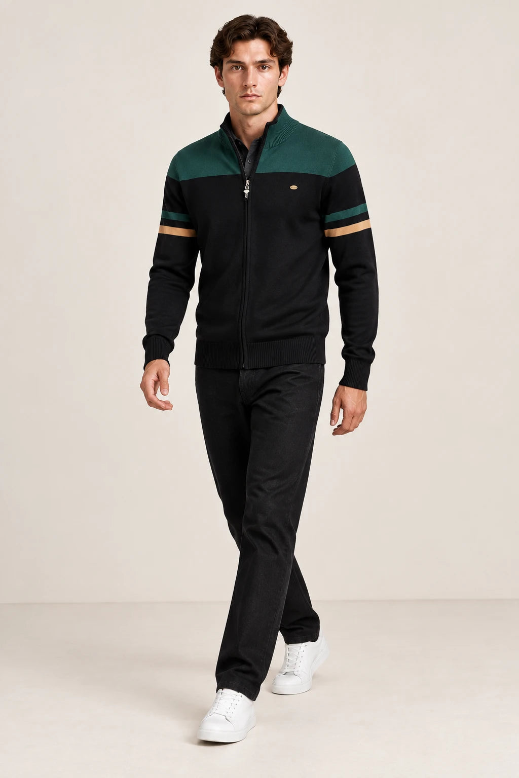 Gilet zippé noir et vert foncé à col cheminée, porté en marche de trois-quarts dans le studio IVAREE.