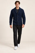 Cardigan bleu foncé en maille épaisse torsadée à col châle et quatre boutons, porté de face dans le studio IVAREE.