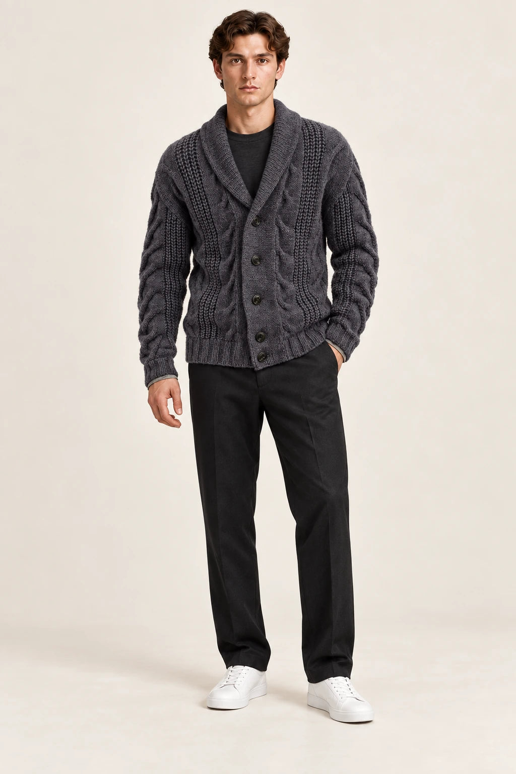 Cardigan gris foncé en maille épaisse torsadée à col châle et quatre boutons, porté de face dans le studio IVAREE.