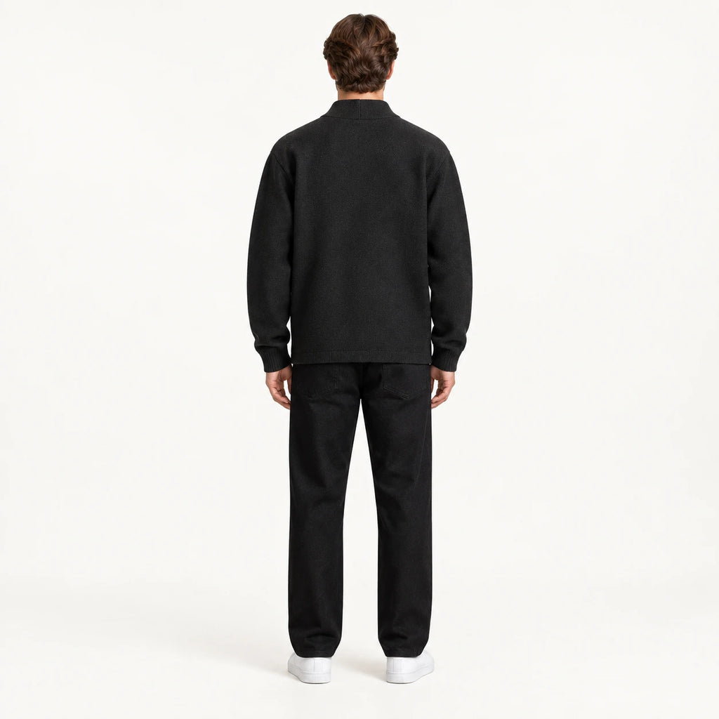 Gilet noir en maille à col montant ouvert, vu de dos dans le studio IVAREE.
