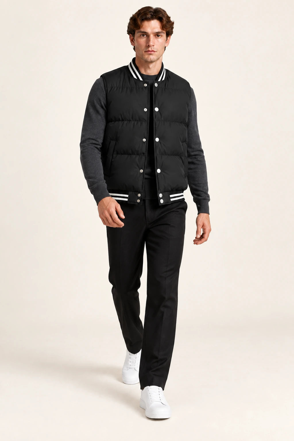 Gilet sans manches noir matelassé à boutons-pression et poches inclinées, porté en marche de trois-quarts dans le studio IVAREE.