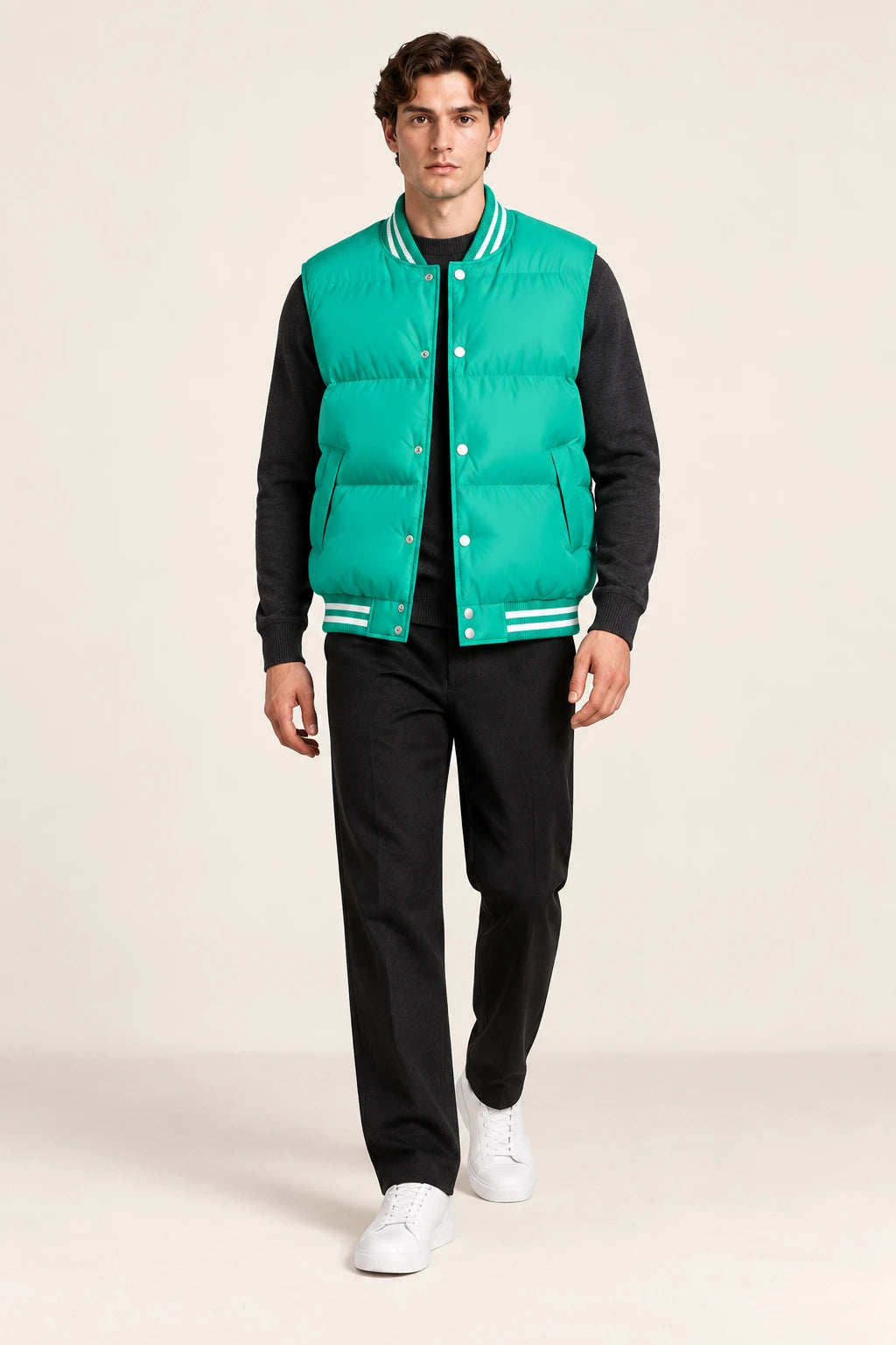 Gilet sans manches vert émeraude matelassé à col et base côtelés rayés, porté de face en marche dans le studio IVAREE.