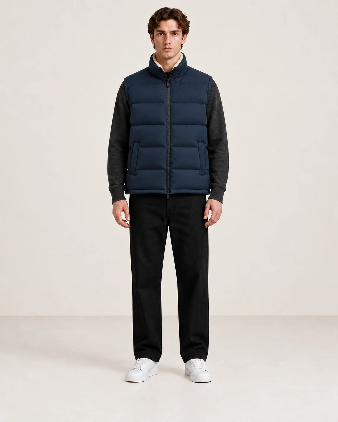 Gilet matelassé bleu marine sans manches et à col montant, porté fermé de face dans le studio IVAREE.