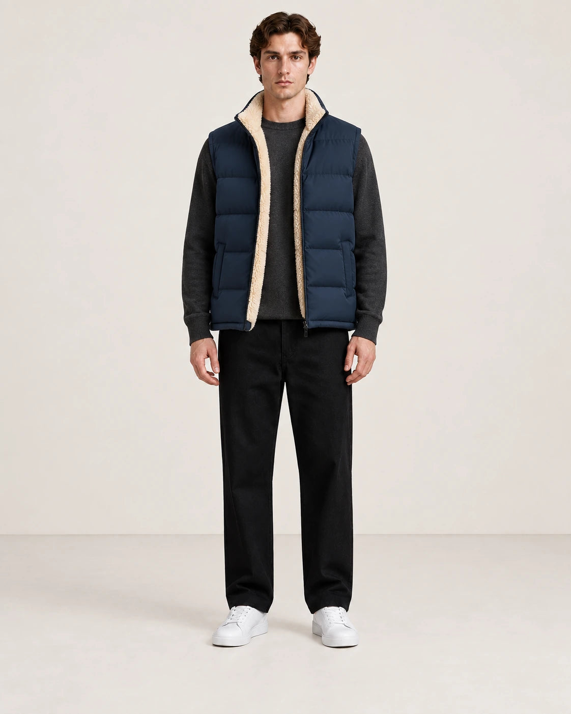 Gilet matelassé bleu marine sans manches, ouvert de face pour montrer la doublure sherpa crème, dans le studio IVAREE.