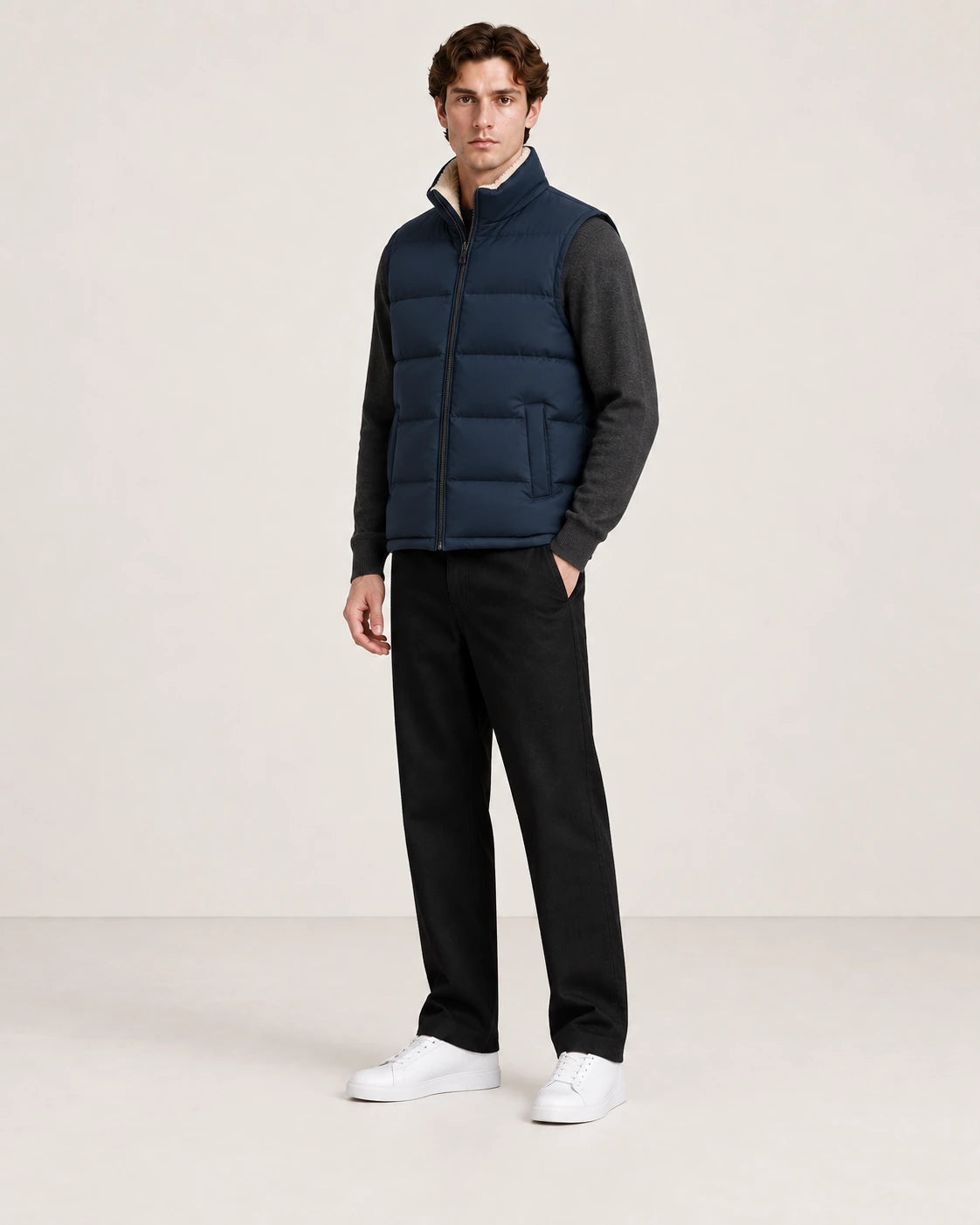Gilet matelassé bleu marine sans manches et à poches plaquées, vu de trois-quarts avant dans le studio IVAREE.