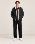Gilet matelassé noir sans manches, ouvert de face pour montrer la doublure sherpa crème, dans le studio IVAREE.
