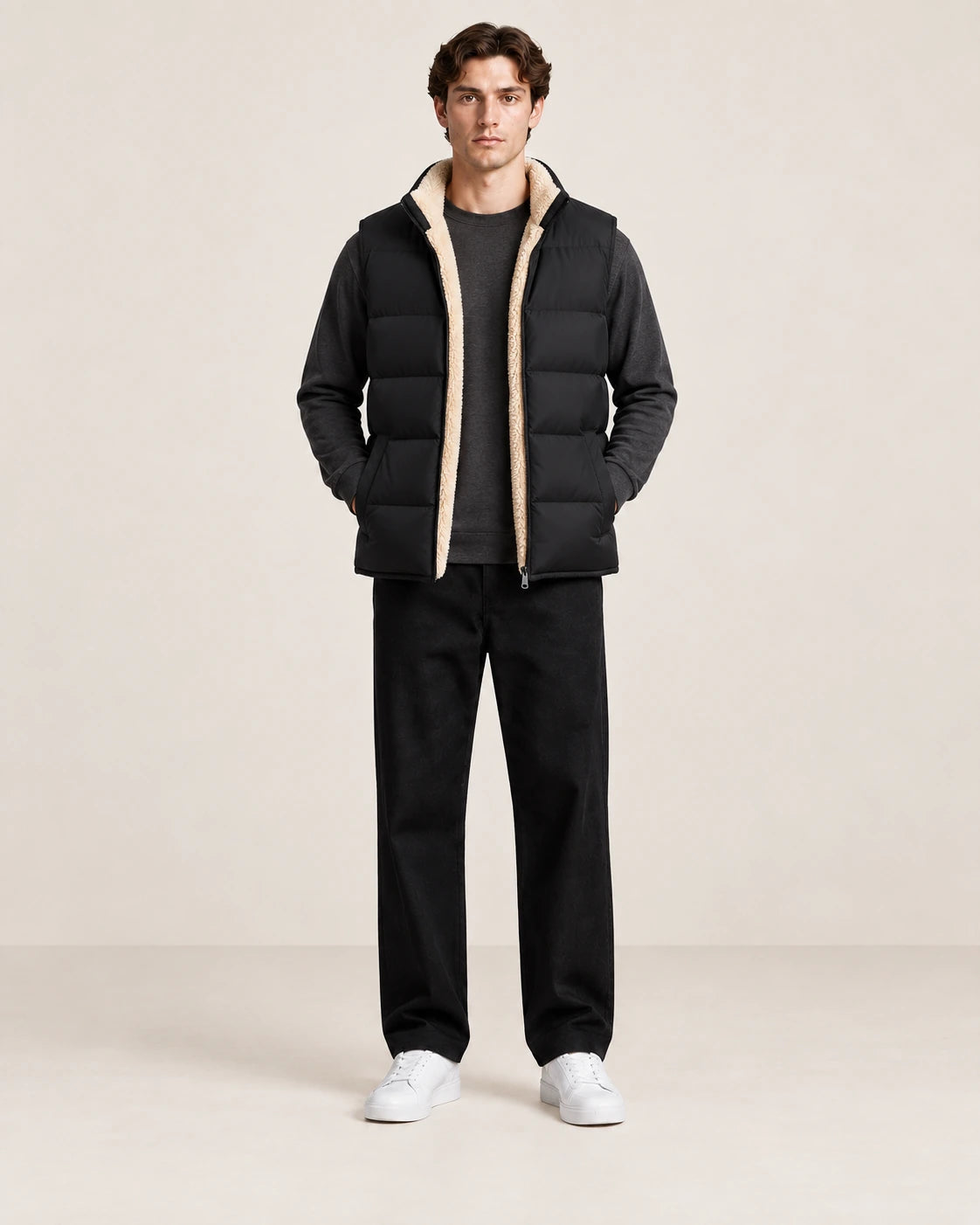 Gilet matelassé noir sans manches, ouvert de face pour montrer la doublure sherpa crème, dans le studio IVAREE.