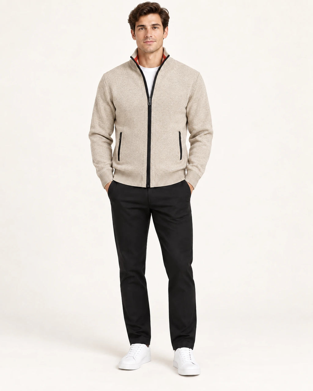 Gilet beige en maille fine avec col montant, fermeture centrale et deux poches zippées, porté de face dans le studio IVAREE.