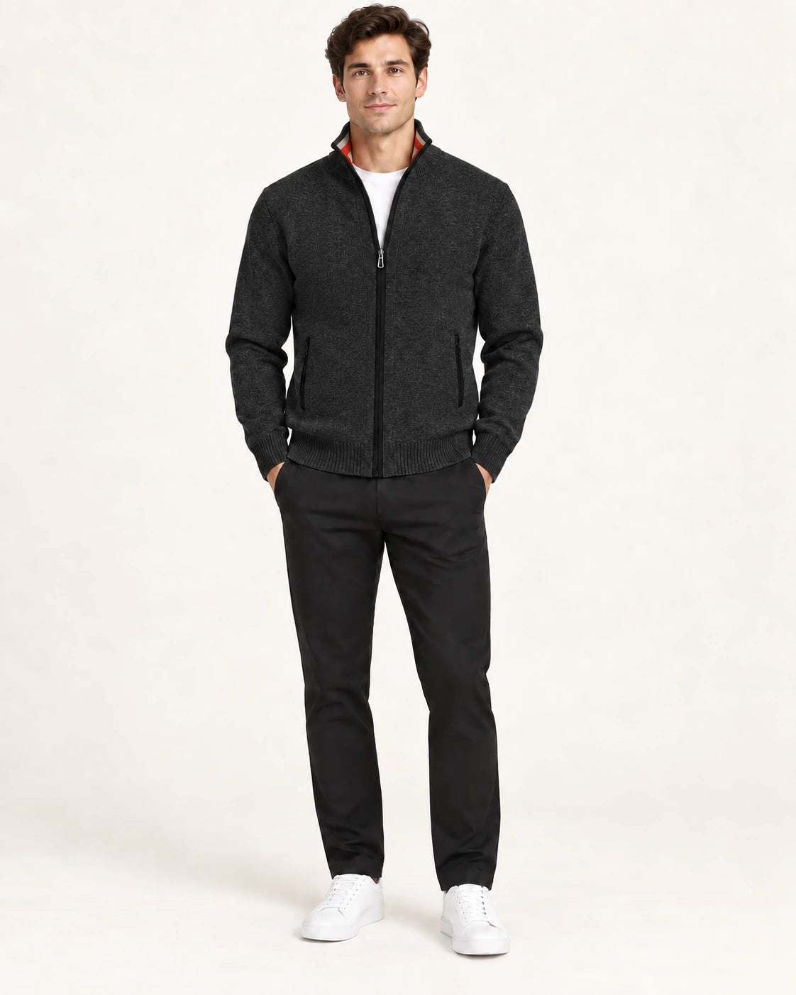 Gilet noir en maille fine avec col montant, fermeture centrale et deux poches zippées, porté de face dans le studio IVAREE.