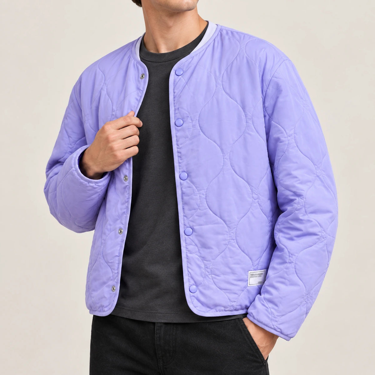 Détail du col rond, des pressions et du matelassage ondulé du manteau violet IVAREE.
