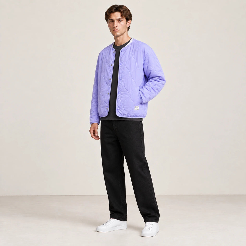 Manteau matelassé violet oversize porté de trois-quarts dans le studio IVAREE.