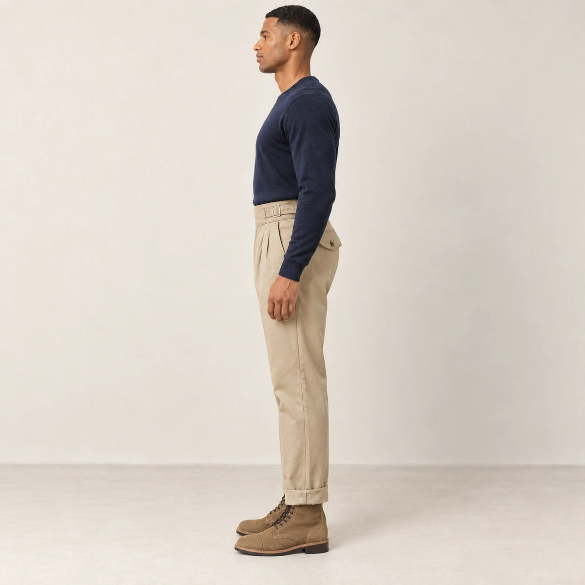 Pantalon kaki à pinces, profil dans le studio IVAREE